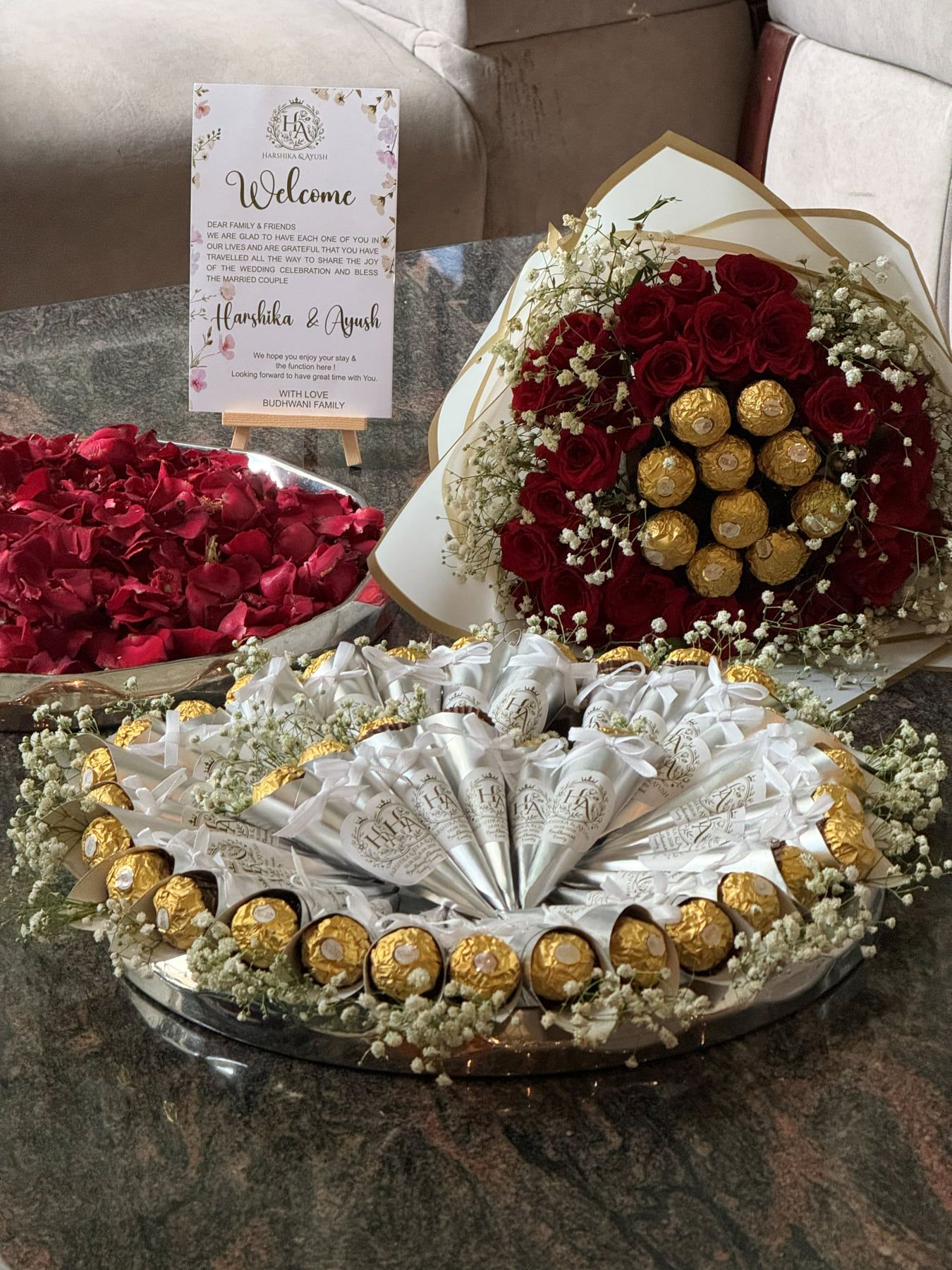 Red rose and Ferrero Rocher bouquet beside a round platter of silver chocolate cones and rose petal trays